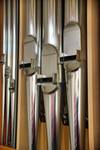 Detailaufnahme einer Kirchenorgel mit Blick auf die Orgelpfeifen. Seitlich aufgenommen im Hochformat.